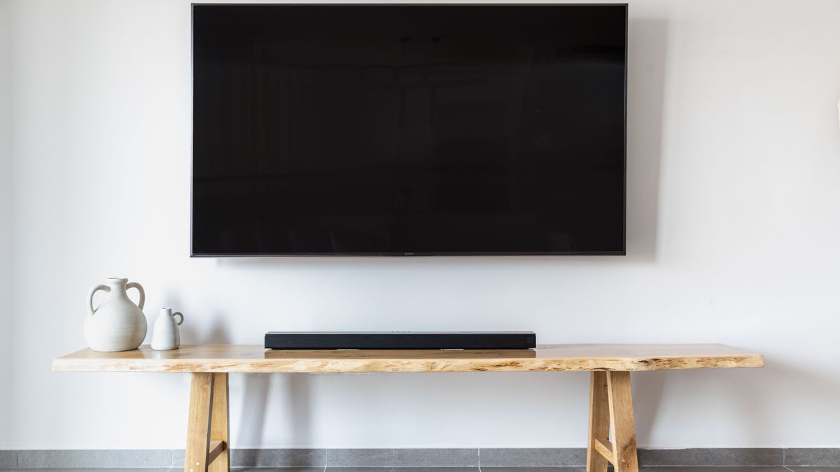 Stylish minimalist living room featuring a wall-mounted flat screen TV and wooden console.