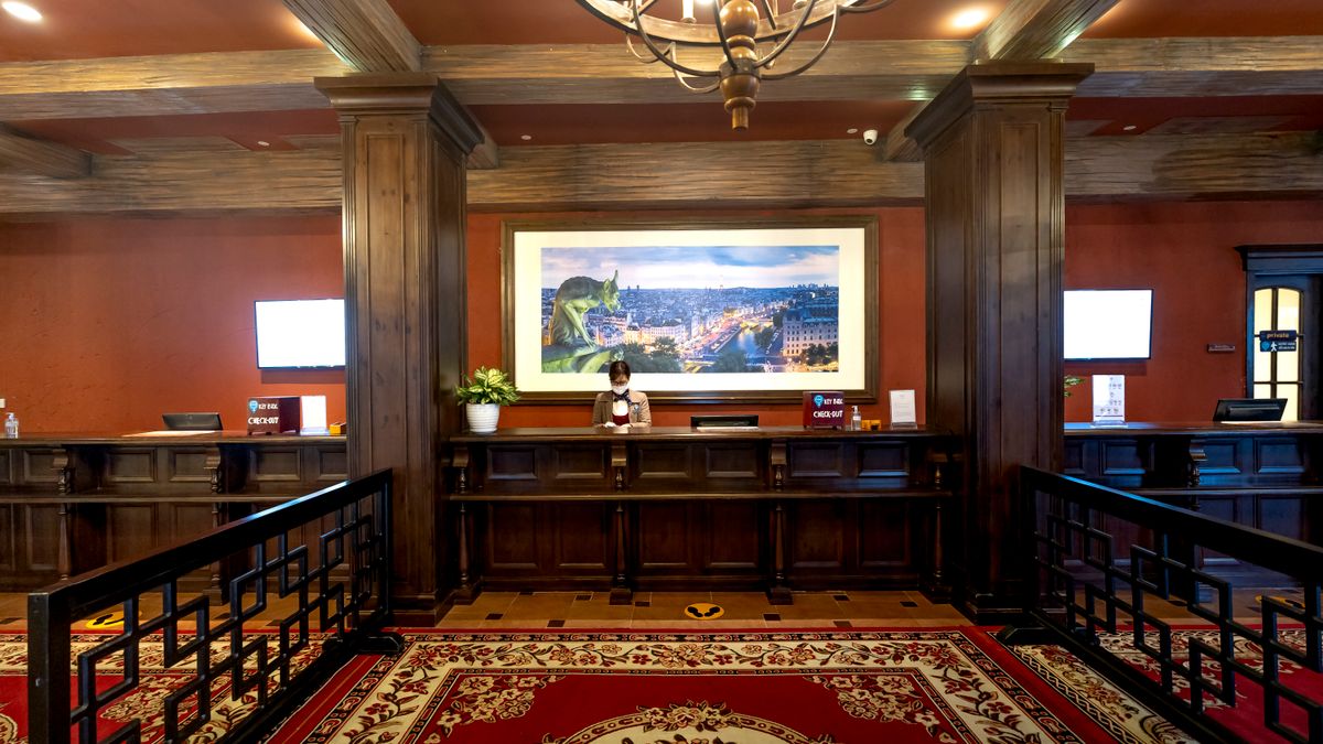 Elegant hotel lobby showcasing a receptionist at the front desk under warm lighting.